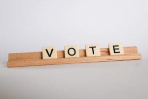 Scrabble tiles with letters spelling "Vote"