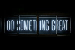 A blue neon sign reading "Do something great"